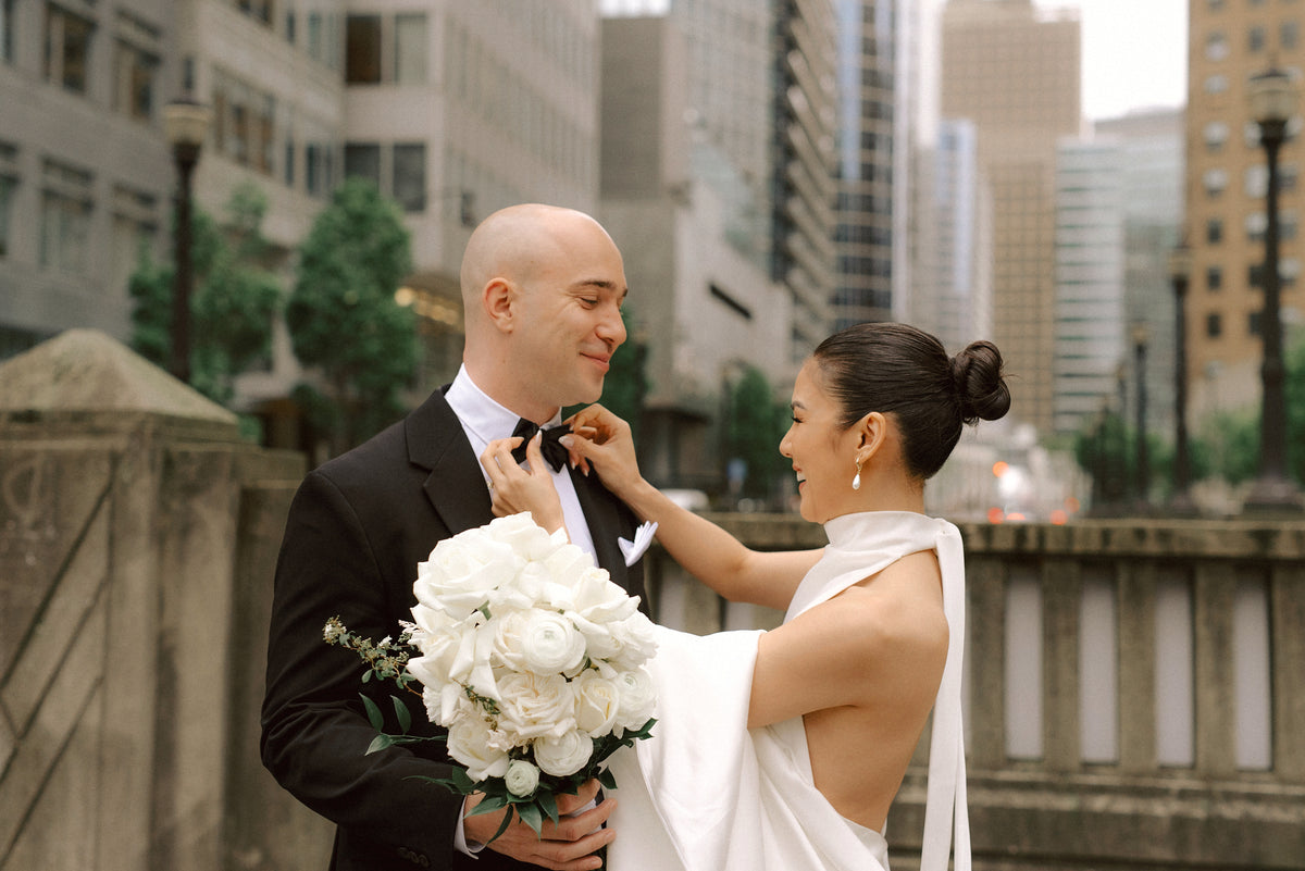 Bride and groom with a white rose bouquet by By Yours Truly